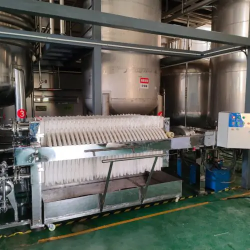 Yeast filter press in operation at food processing plant, industrial filtration equipment for yeast slurry dewatering
