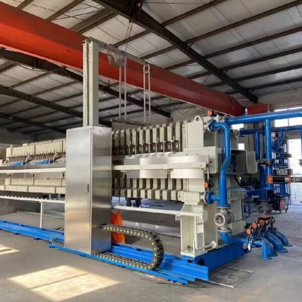Industrial membrane filter press in a factory workshop, showing hydraulic cylinders, filter plates and control panel.